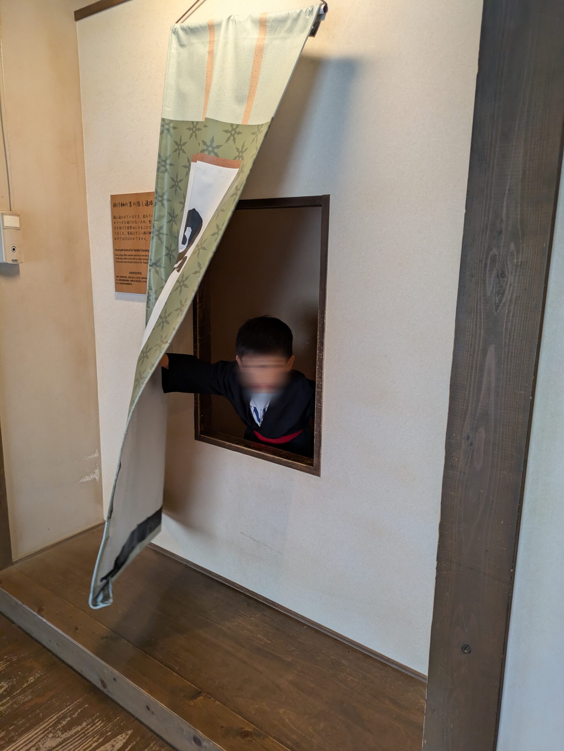 からくり屋敷の隠し窓から出る子ども